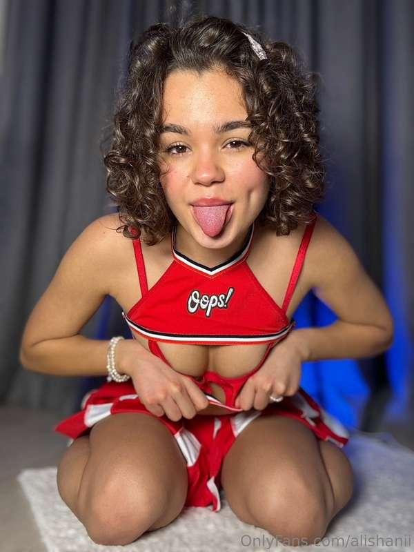 I strike a playful pose, my cheerleader skirt swishing aroun..
