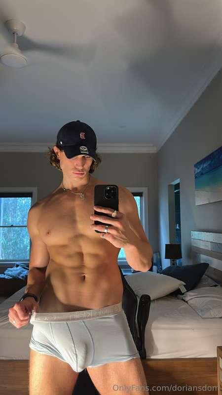 Boxers hanging low, abs tight, mirror catching every angle d..