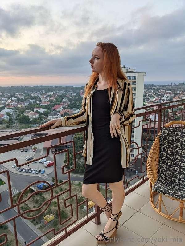 Standing on the balcony at dawn, the soft glow of the rising..