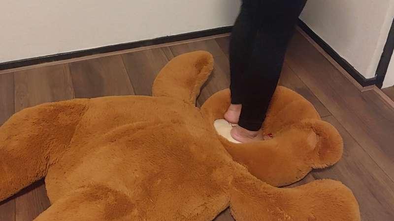 Sandra is abusing her biggest teddybear with her feet