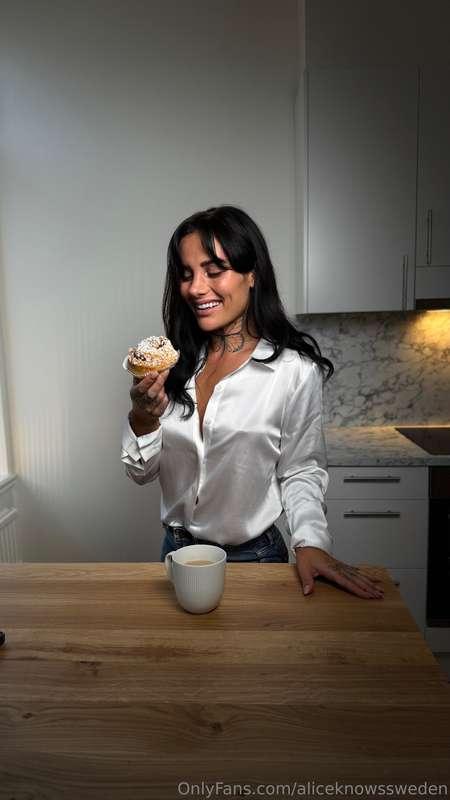 Savoring a sweet fika moment—coffee, a kanelbulle, and a smi..