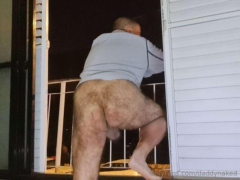 Bottomless daddy looking across the street from his balcony,..