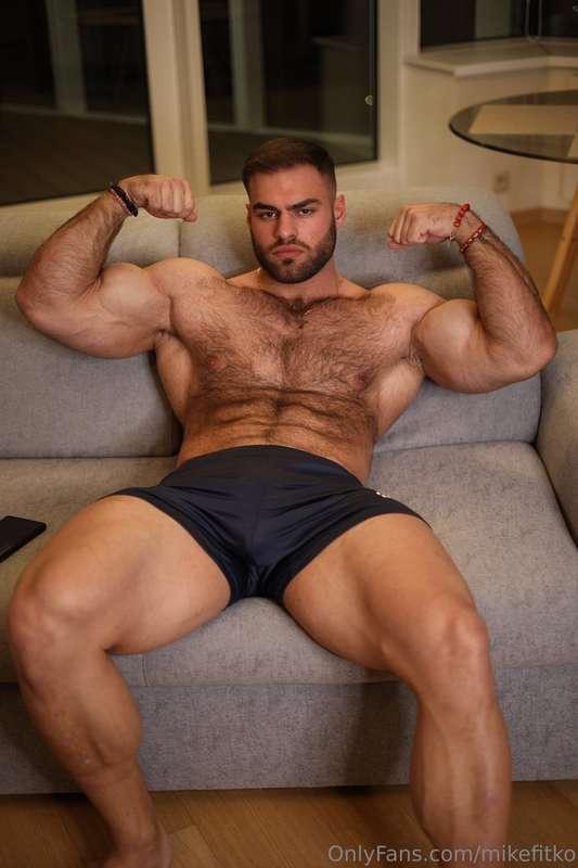 Posted on the couch, shirt off, flexed up, cock thick and ha..