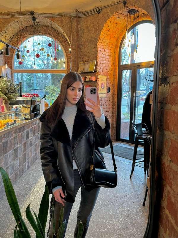 A stylish black sheepskin coat is not just a piece of clothi..