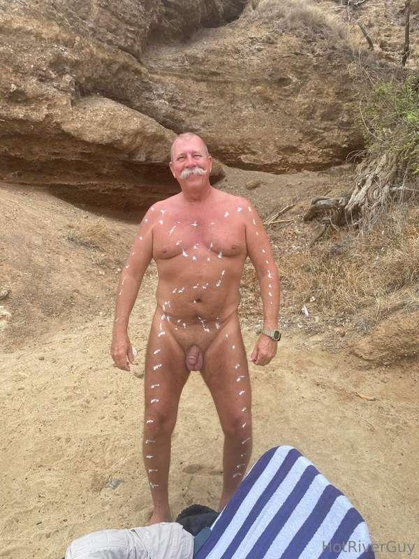 Applying sunscreen while at the nude beach.