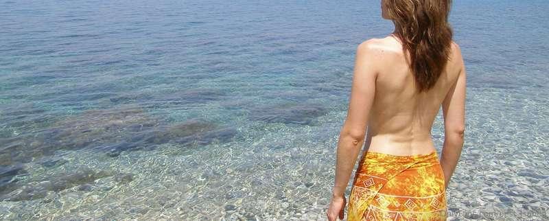 Topless shy girl on the beach
