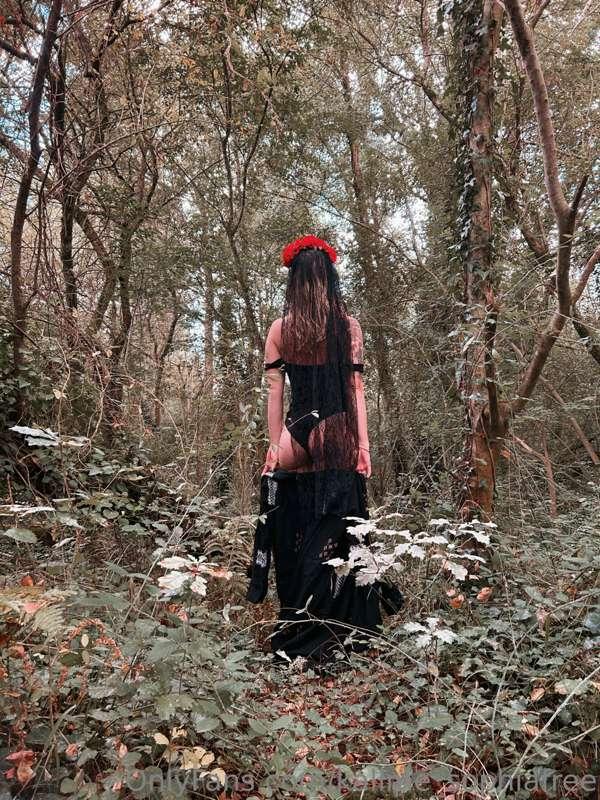 A skeleton that is taking her clothes off in the forest!