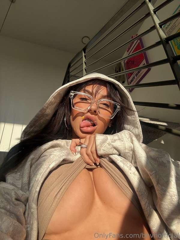 Sun-kissed and cheeky—tongue out, tits barely holding it tog..