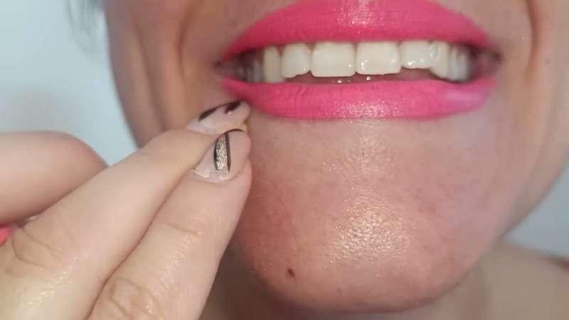 Young woman with thin lips, but a wide mouth, wearing extra pink lipstick