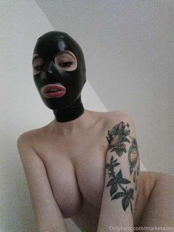 Wearing nothing but a latex hood.