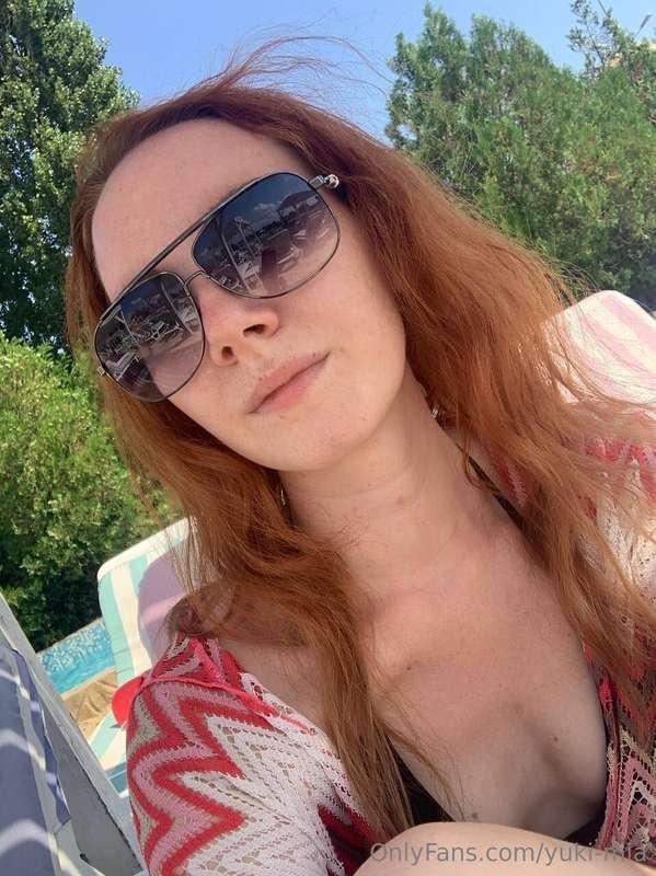 Lounging by the pool, the sun glinting off her glasses as sh..