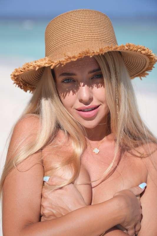 On the beach, under the sun, wearing my hat and covering my ..