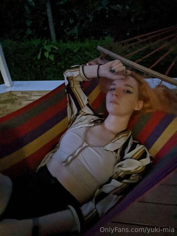 Swinging gently under the shade of a tree, the breeze playin..