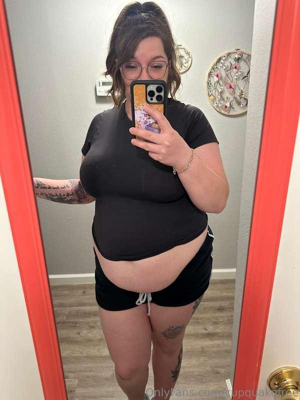 Folding clothes while wearing a small, tight shirt that expo..