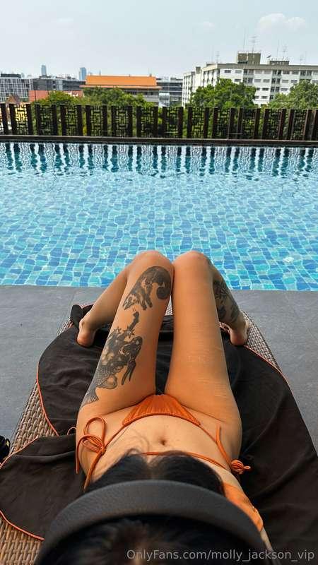 Lying on a chaise lounge, enjoying the moment under the warm..