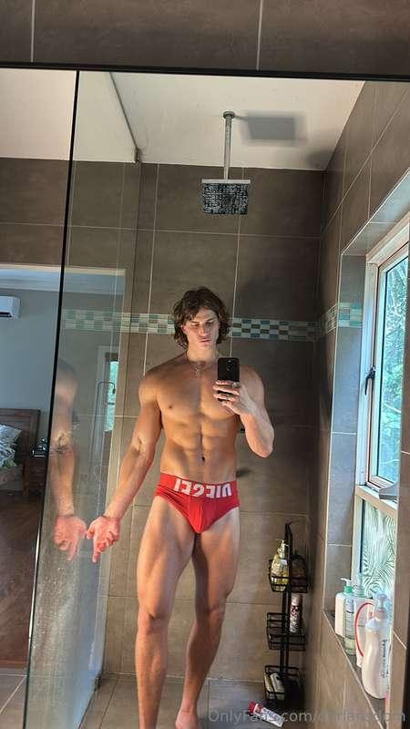 In the bathroom mirror, half naked, abs poppin’, and this fa..