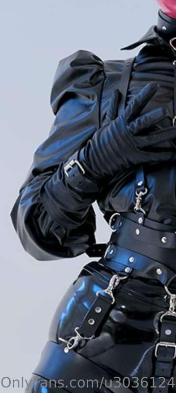 All black outfit of latex and leather- only the hood is pink..