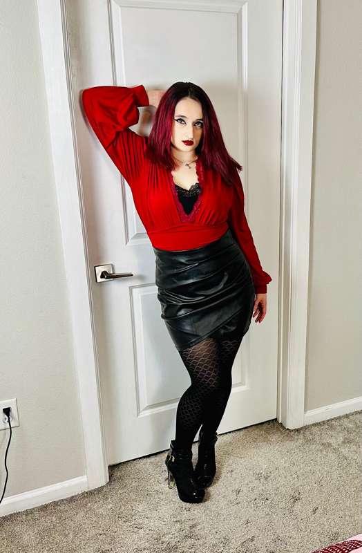 Hot red satin blouse with a tight fitting black leather skir..