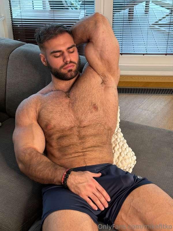 Stretched out on the couch, flexing for you—one hand on my b..