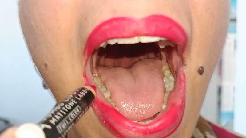 Red lip liner on full lips and a wide mouth for a young woman