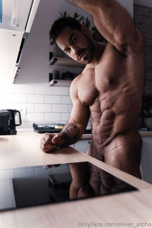 Standing in the kitchen naked, cock just teasing to slip int..