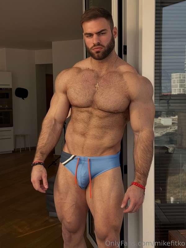 Leaning on the sliding glass door, body half bare, cock thic..