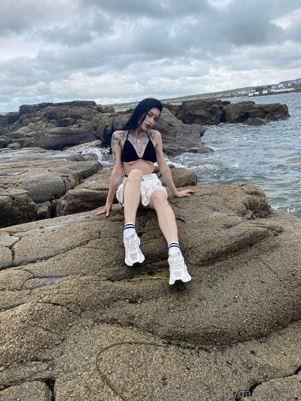 Beside the brooding sea, I stand as a gothic vision in the d..