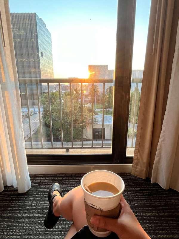 Watching the sun rise from my hotel room with a cup of coffe..